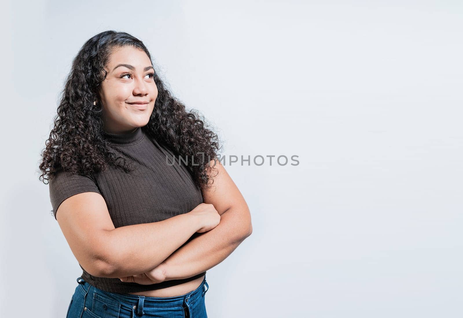 Attractive thoughtful girl with crossed arms isolated. Latin girl imagining with crossed arms. People thinking things on isolated background by isaiphoto