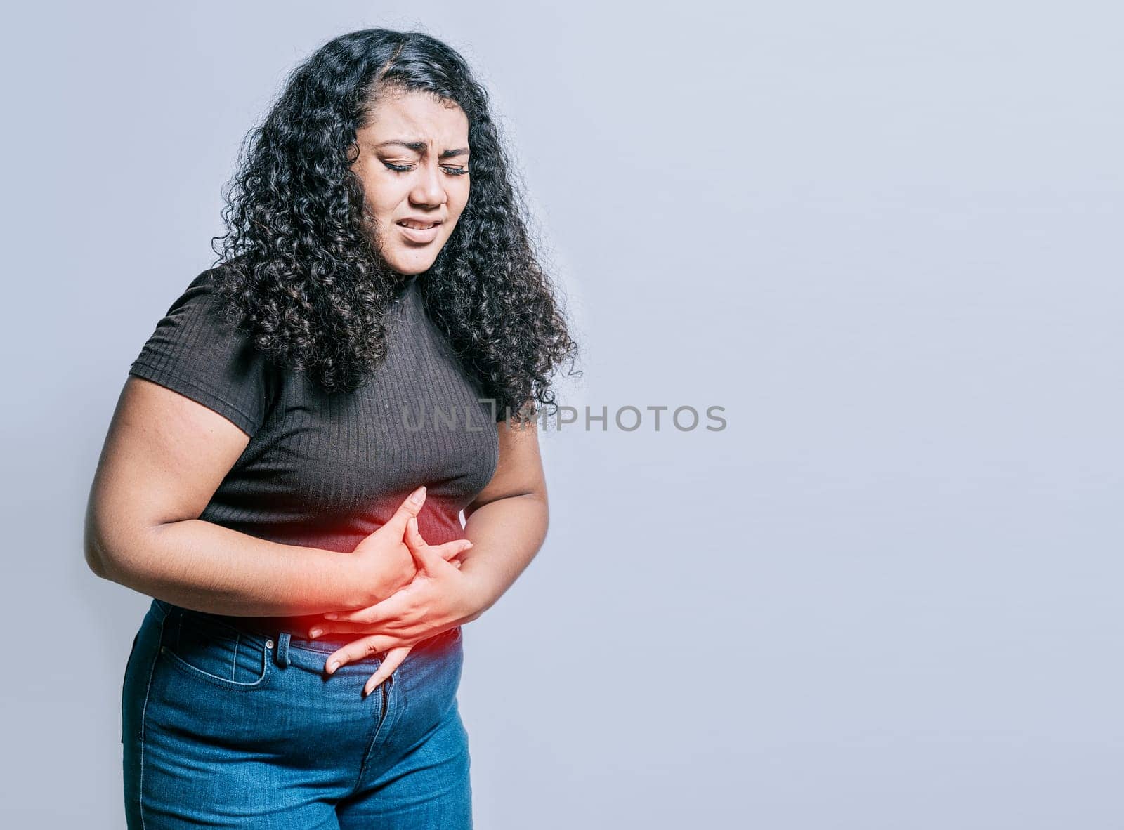 Woman with abdominal pain isolated. Young woman suffering stomach pain. Person with stomach pain isolated by isaiphoto