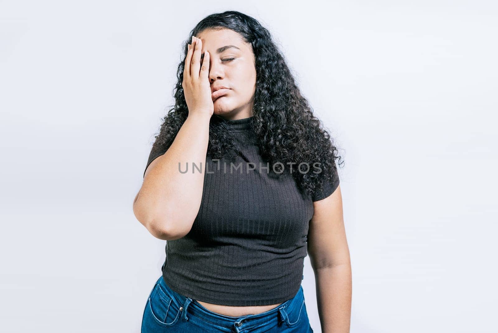 Tired and exhausted woman holding her forehead. Worried young woman holding his forehead. Exhausted woman with palm on forehead isolated by isaiphoto