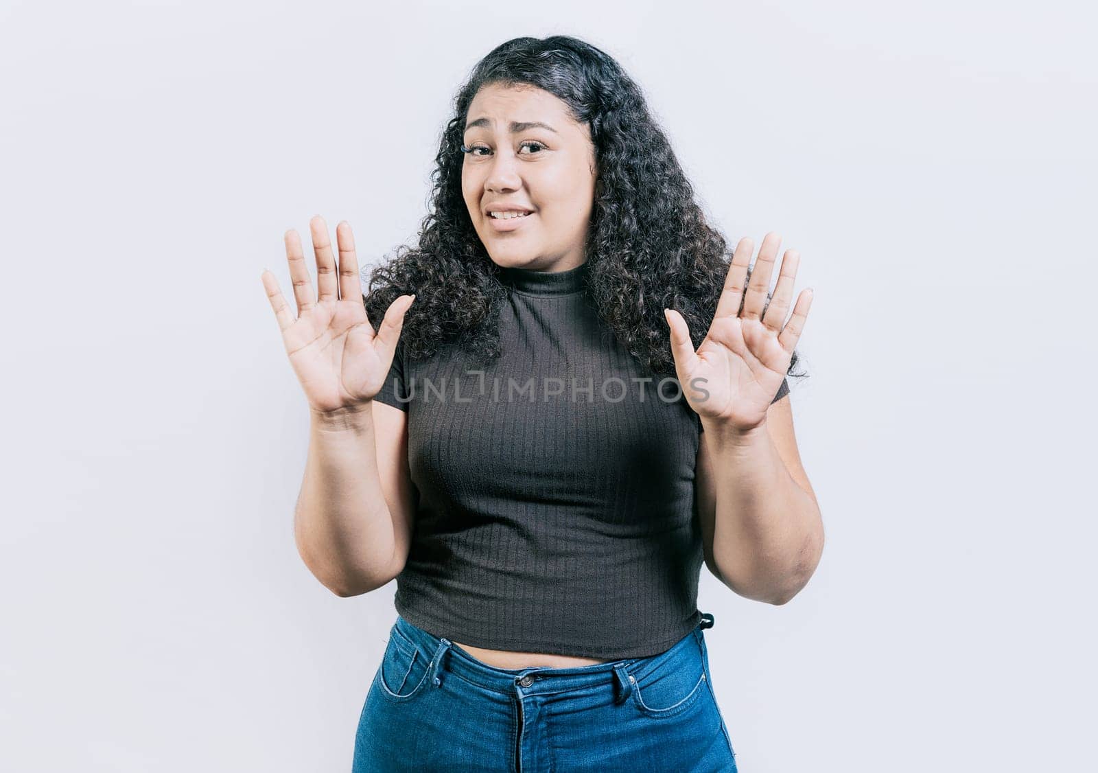 Woman with face disgusted raising hand isolated. Girl with disgust face isolated. Latin girl with expression of disgust isolated by isaiphoto