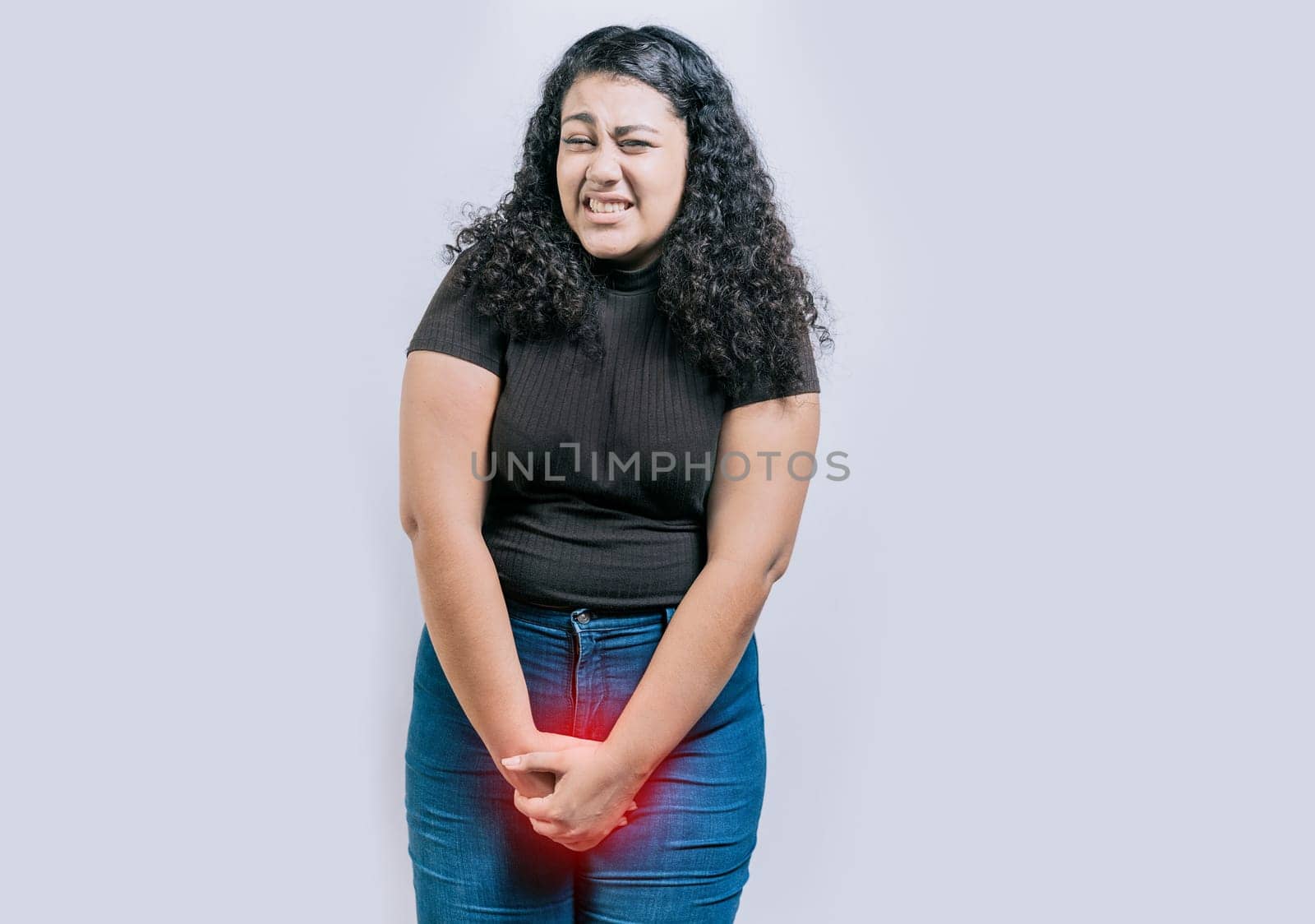 Girl with hands on crotch with urinary problems. People with urinary incontinence on white background. Young woman with urinary problems isolated by isaiphoto