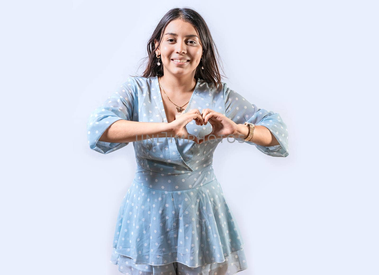 Funny young girl making heart shape with hands. Teen girl making heart shape with her hands. Happy girl making heart shape with hands isolated by isaiphoto