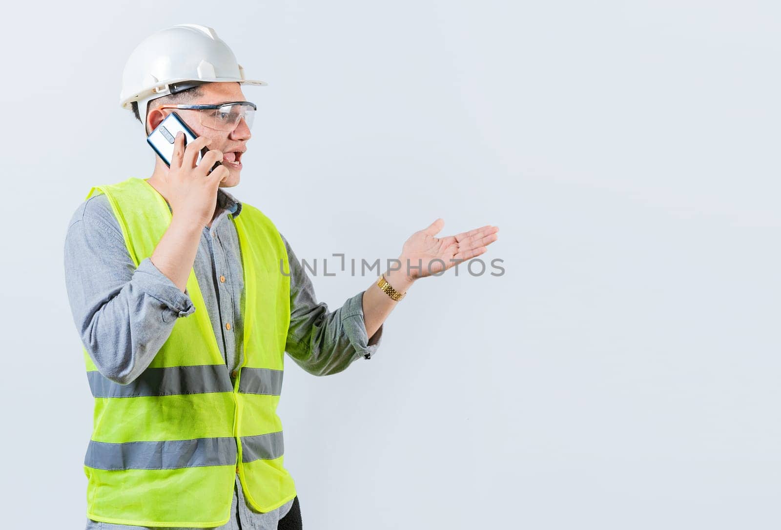 Young engineer calling on cell phone isolated. Civil engineer talking on phone isolated on white background by isaiphoto