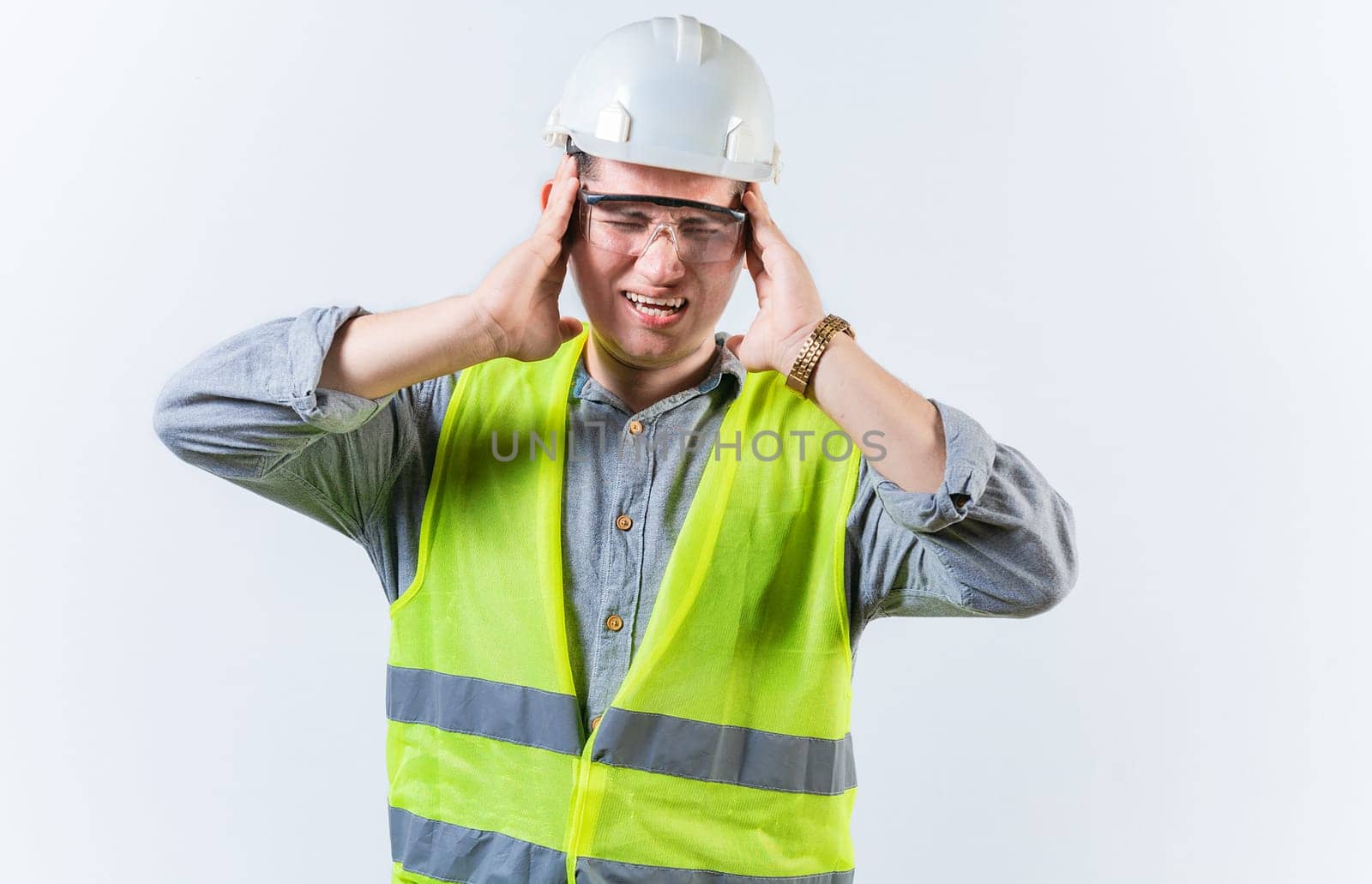 Male engineer with headache on isolated background. Young engineer with migraine holding his head isolated by isaiphoto