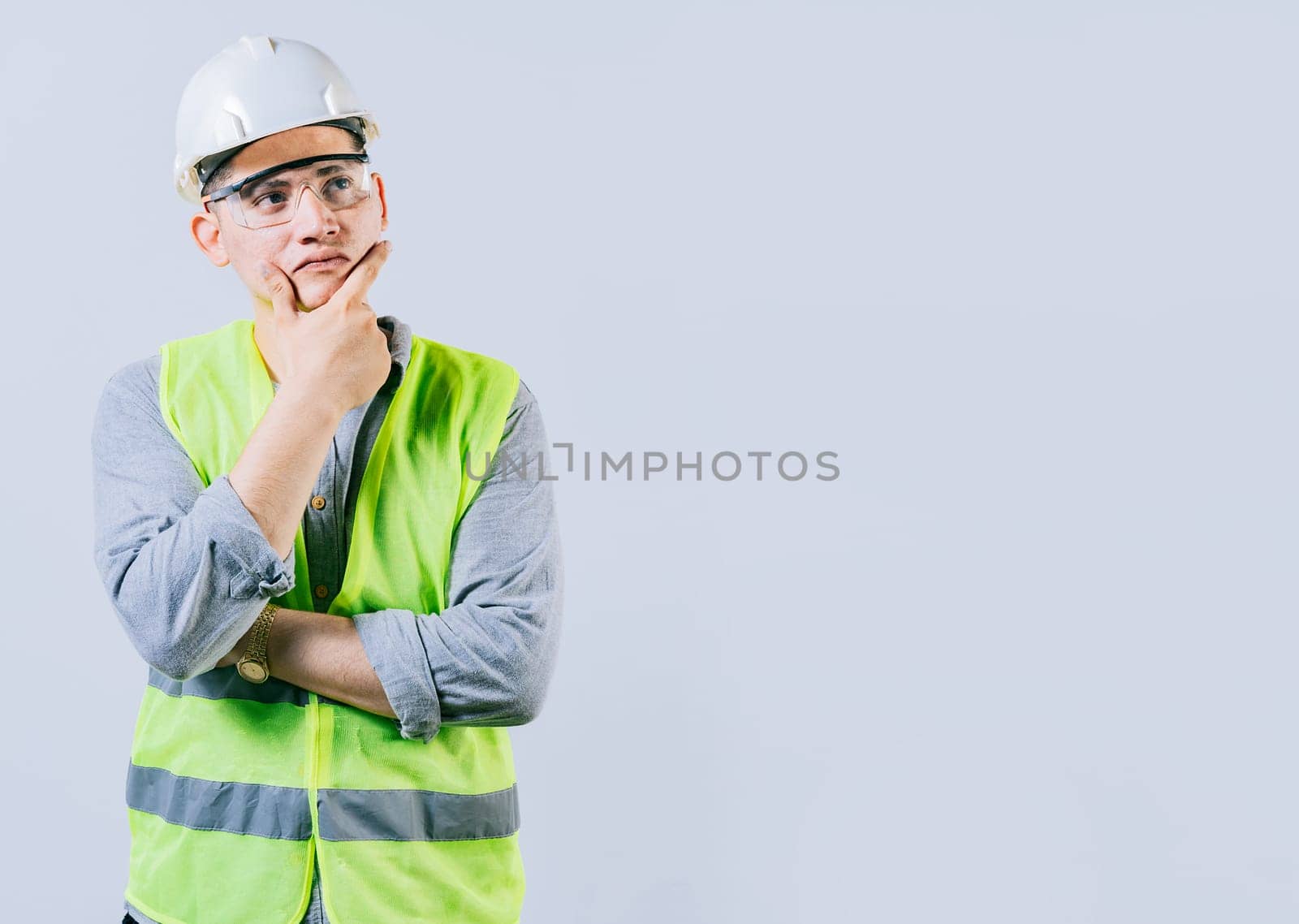 Pensive male engineer with hand on chin isolated. Pensive man engineer looking side. Portrait of handsome engineer thinking with hand on chin by isaiphoto