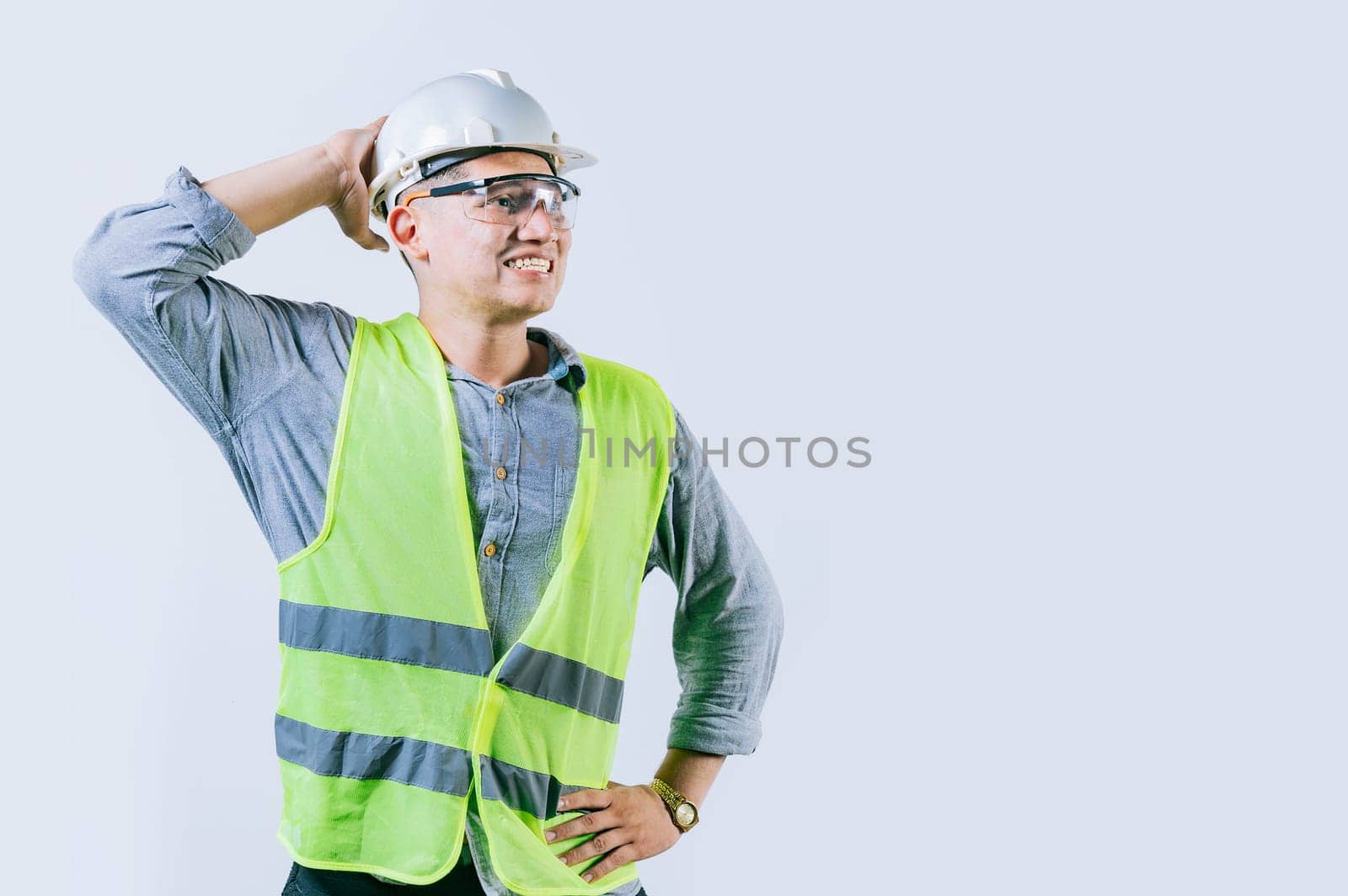 Worried builder engineer holding his head isolated. Troubled young engineer holding his head looking up. Worried male engineer man holding his head by isaiphoto