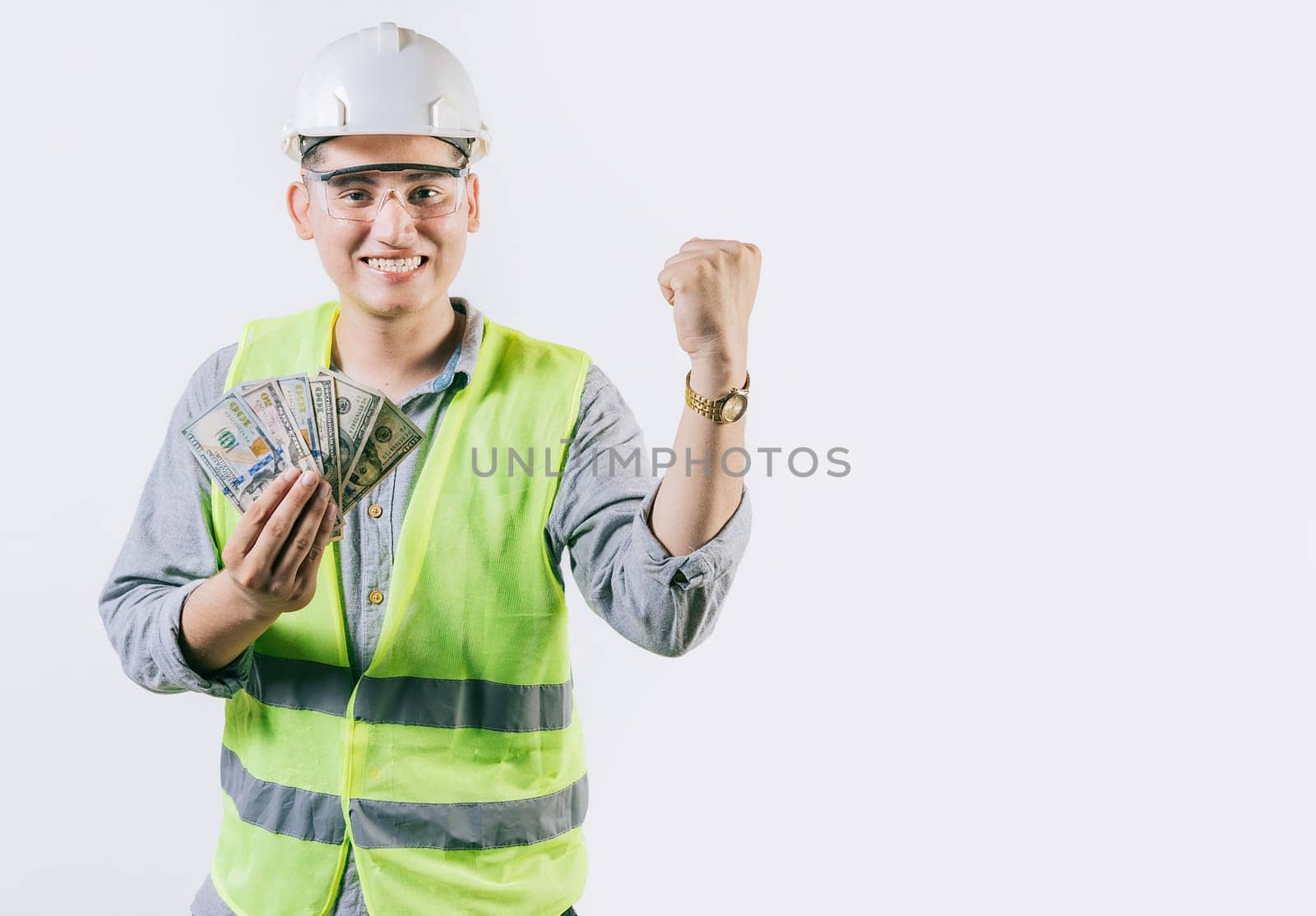Happy engineer holding money celebrating isolated. Excited engineer holding banknotes and celebrating an award isolated by isaiphoto