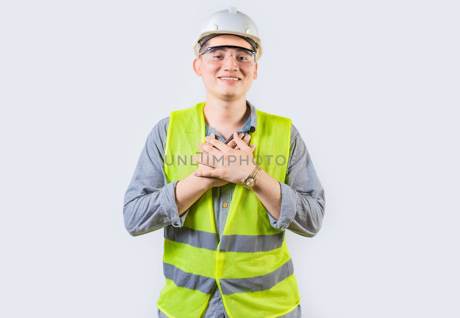 Portrait of young engineer with grateful gesture. Handsome grateful engineer with hands on chest isolated by isaiphoto