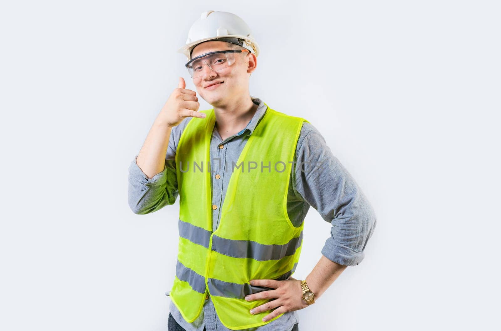 Portrait of young engineer making call gesture isolated. Handsome engineer making call gesture with fingers by isaiphoto