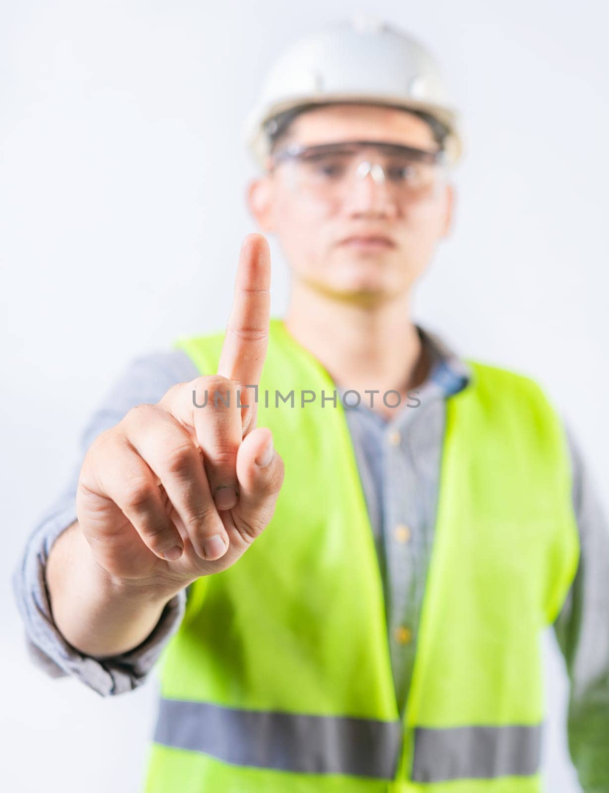 Young engineer counting number one isolated. Male engineer showing number one isolated by isaiphoto