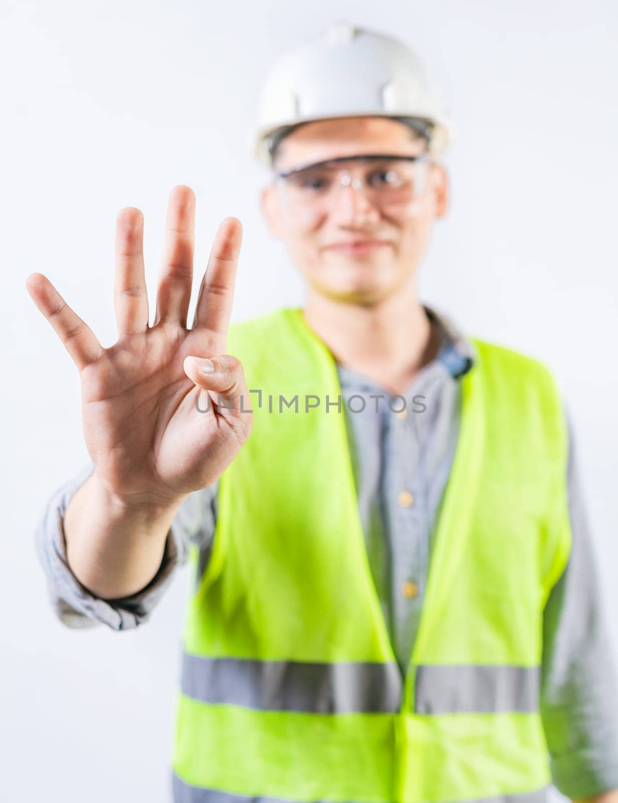 Young engineer counting number four isolated. Male engineer showing number four with fingers isolated by isaiphoto