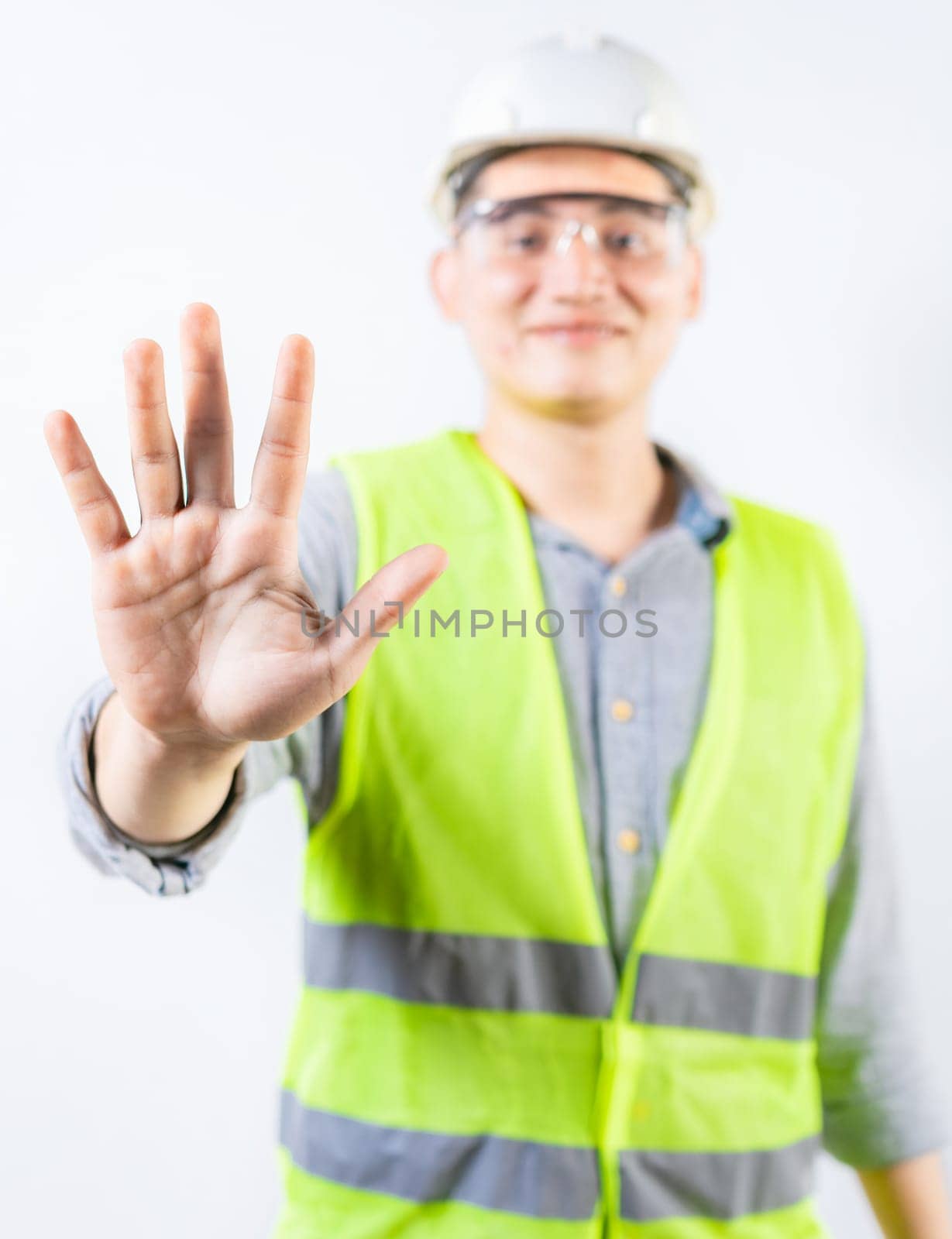 Young engineer counting number five isolated. Smiling engineer showing number five with hand isolated by isaiphoto