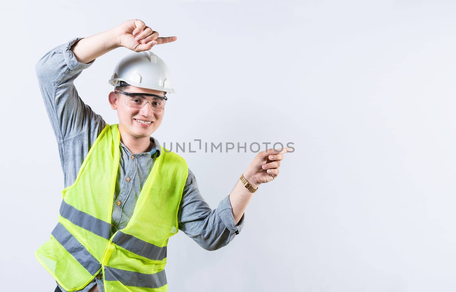 Portrait of smiling engineer pointing aside isolated. Handsome engineer pointing an advertisement isolated