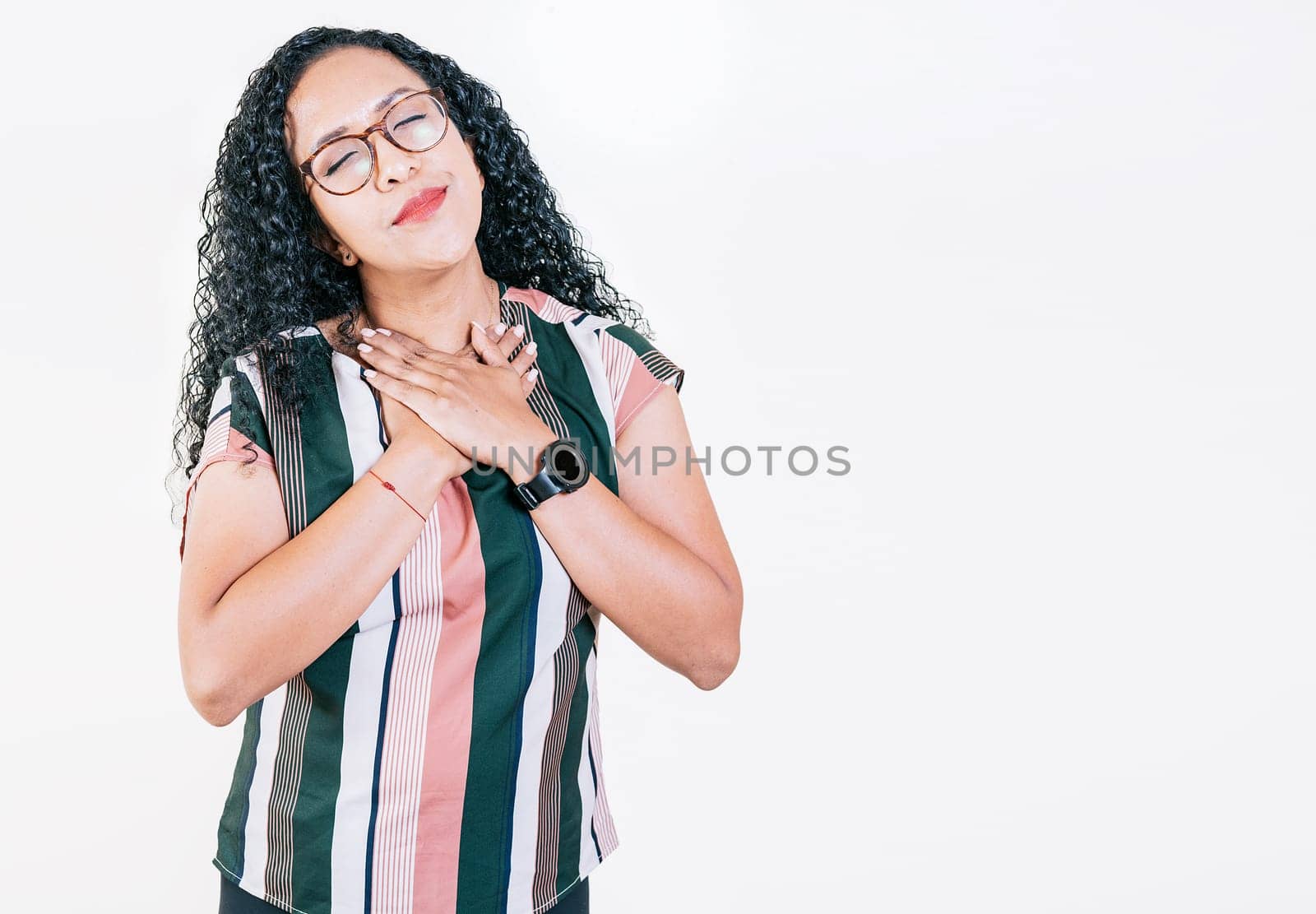 Positive afro woman with lovely sincere smile feeling thankful, relaxed afro girl showing thank you gesture with hands on chest, Grateful people concept by isaiphoto