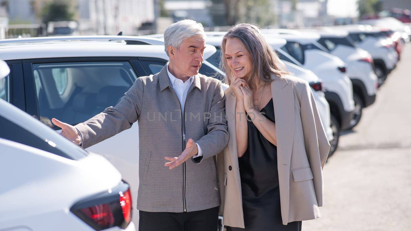 An elderly Caucasian man gives a new car to his beloved woman