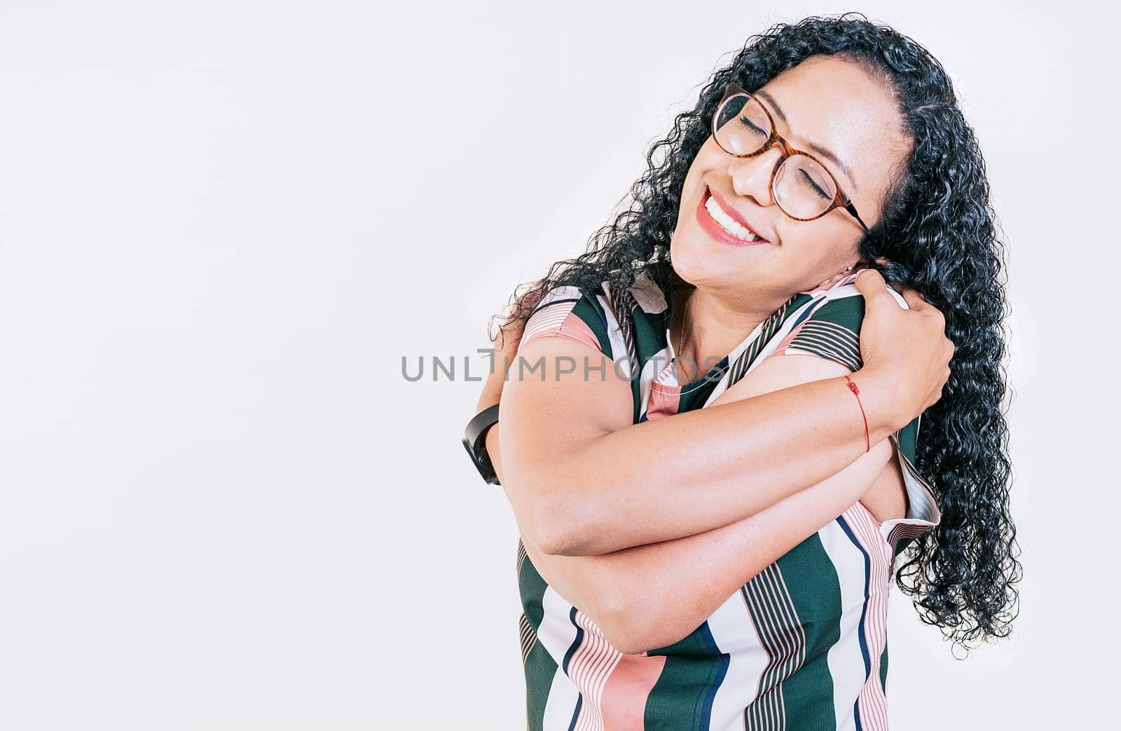 Smiling young woman hugging herself with self love. Self love concept. Afro woman hugging herself isolated by isaiphoto