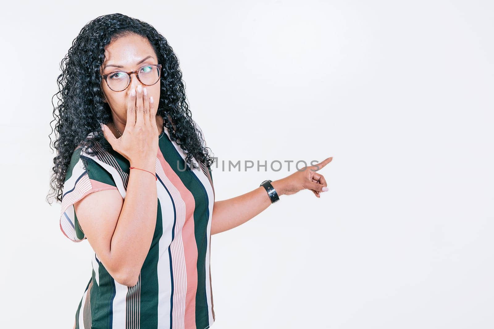 Afro young woman pointing an advertising isolated. Girl in glasses pointing to a banner to the side. Funny people pointing a promo isolated by isaiphoto