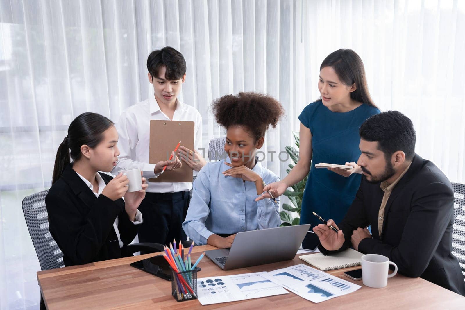 Multiracial analyst team use BI dashboard data to analyze financial report on meeting table. Group of diverse business people utilize data analysis by FIntech for success business marketing. Concord