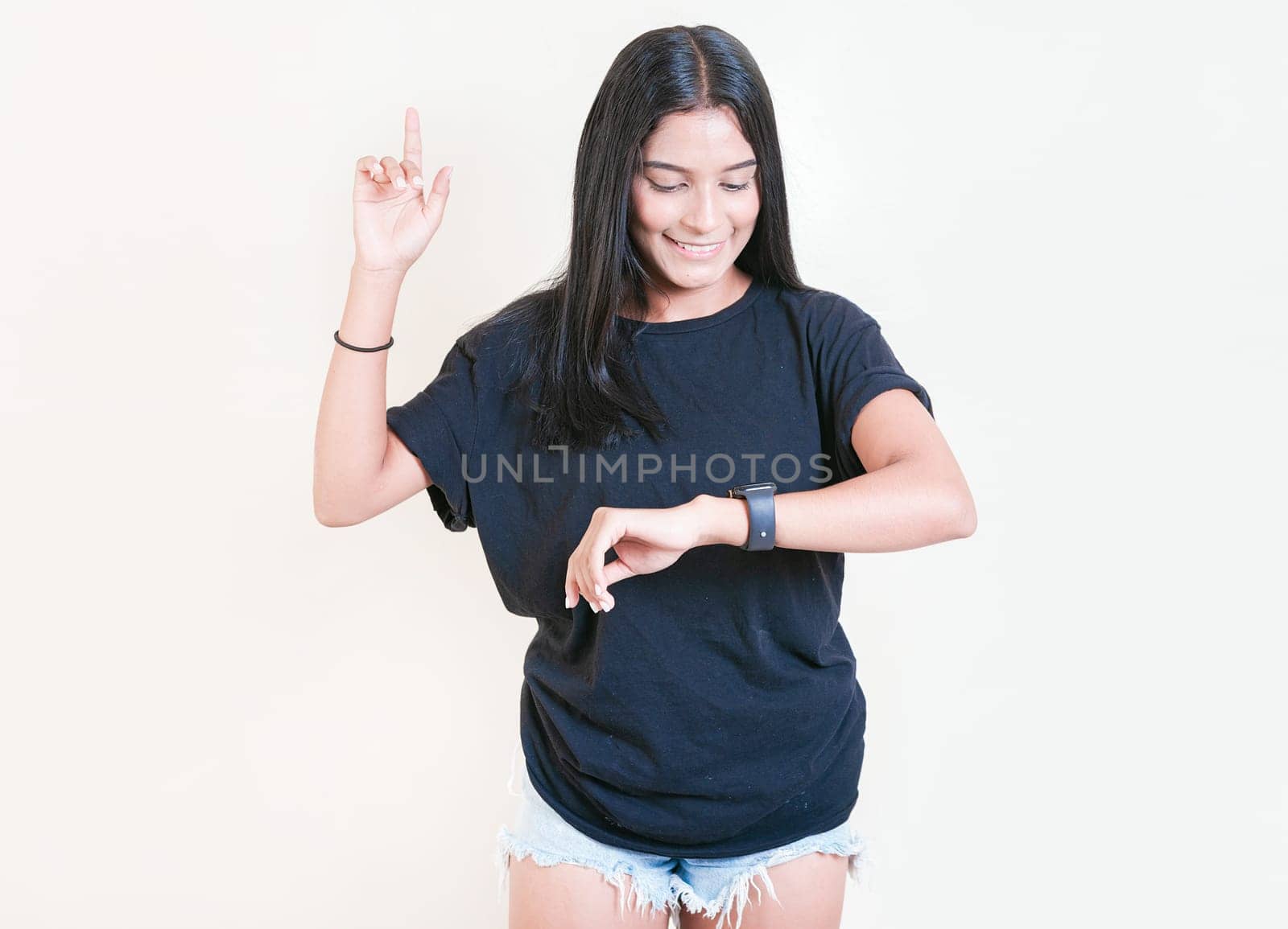 Smiling teen girl looking at hand watch isolated. Happy young woman looking at hand watch isolated by isaiphoto