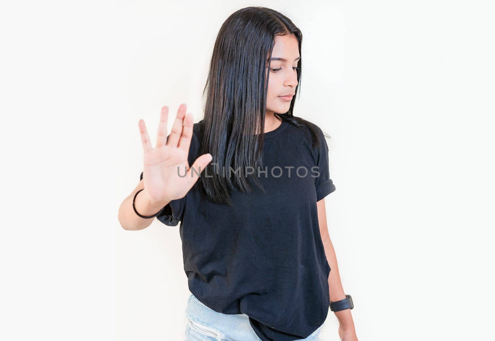 Young girl gesturing stop with palm of hand isolated. Teenage girl rejecting with the palm of her hand. Latin people gesturing stop isolated by isaiphoto