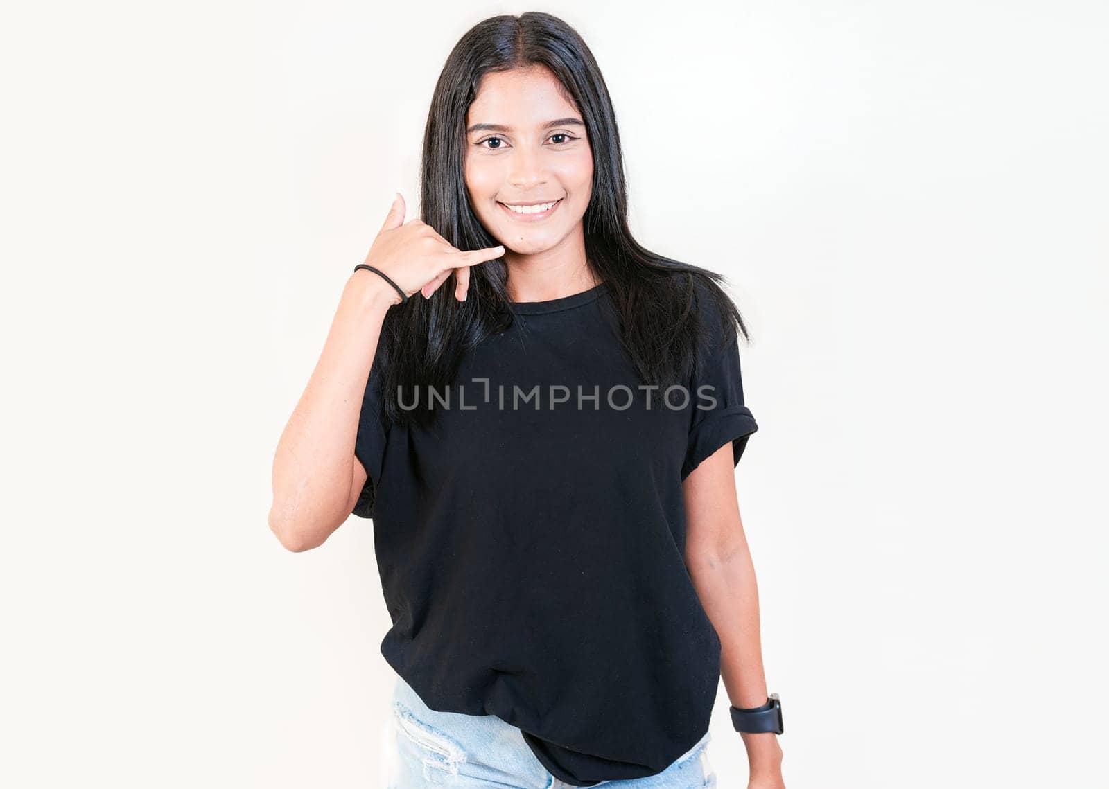 Happy latin girl gesturing call with fingers isolated. Smiling young girl gesturing call me with hand isolated by isaiphoto