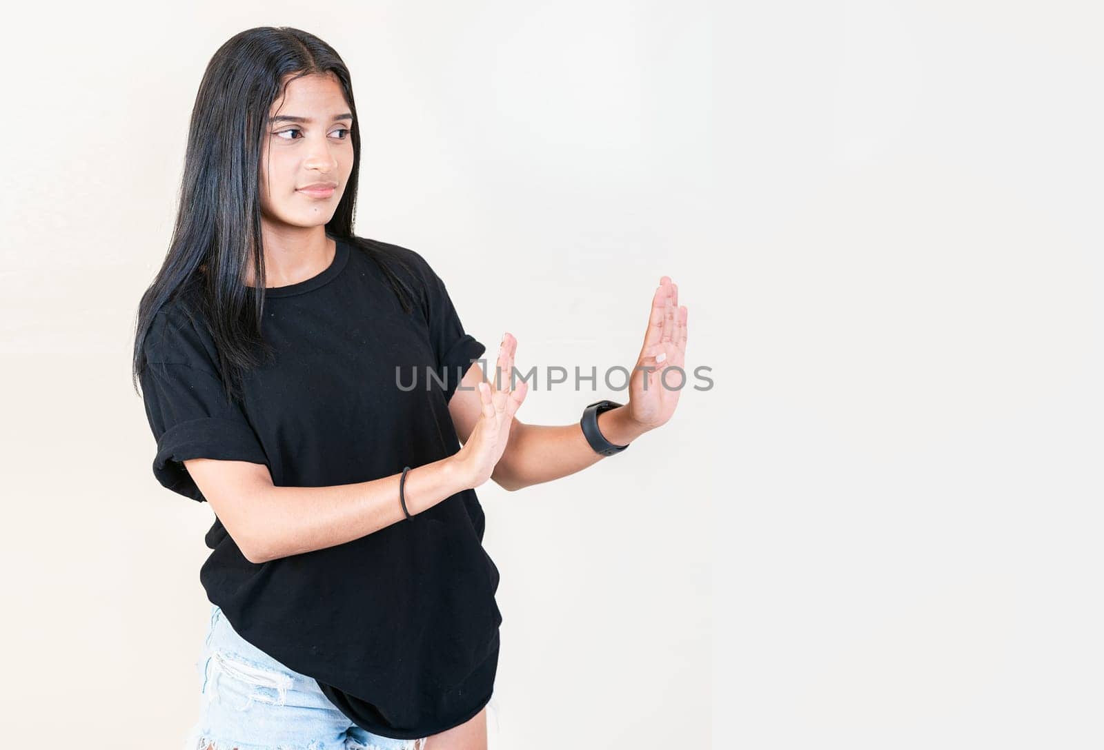 Displeased girl rejecting with palms hands isolated. Intense displeased young girl with rejection gesture. He frowns in disgust by isaiphoto
