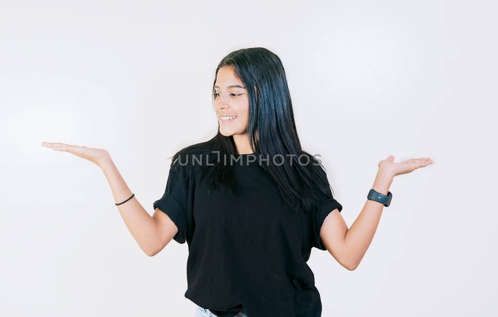 Girl balancing something with palms isolated. Smiling woman comparing with palms with hands isolated by isaiphoto