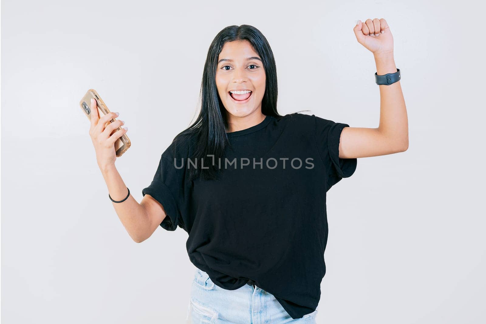 Happy people holding smartphone and celebrating. Winner happy young girl holding cell phone. Happy teen girl celebrating with phone isolated by isaiphoto