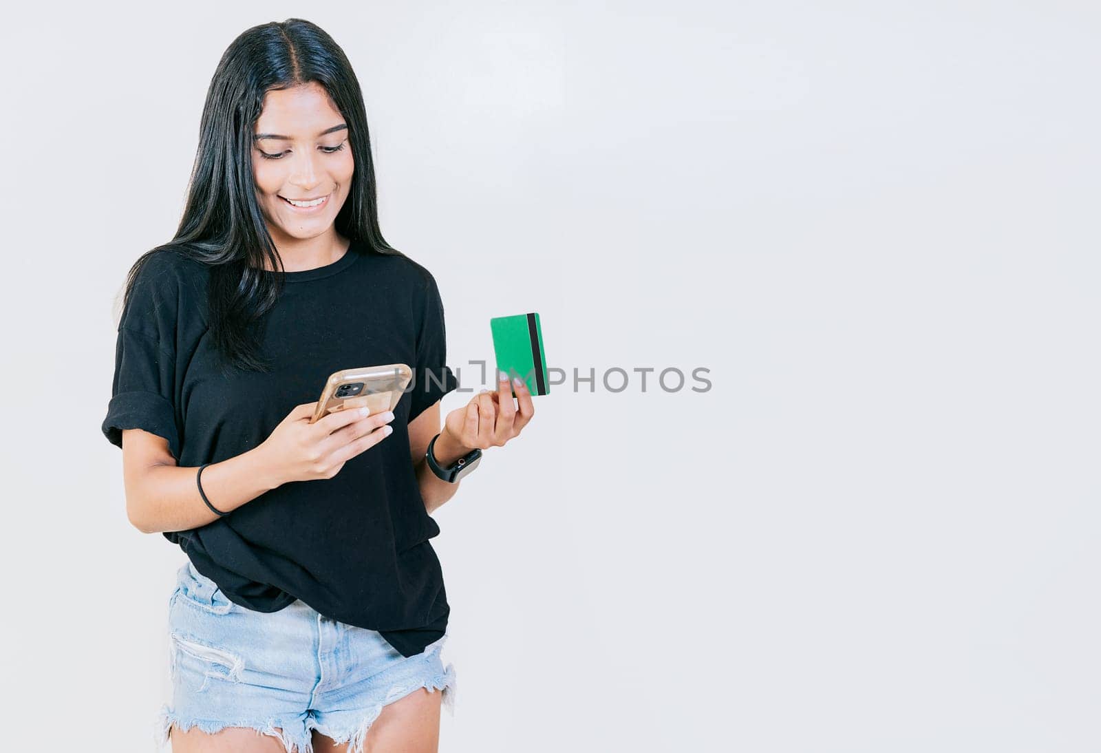 Girl holding credit card shopping online with cell phone isolated. People making online purchases with cell phones and credit cards isolated by isaiphoto