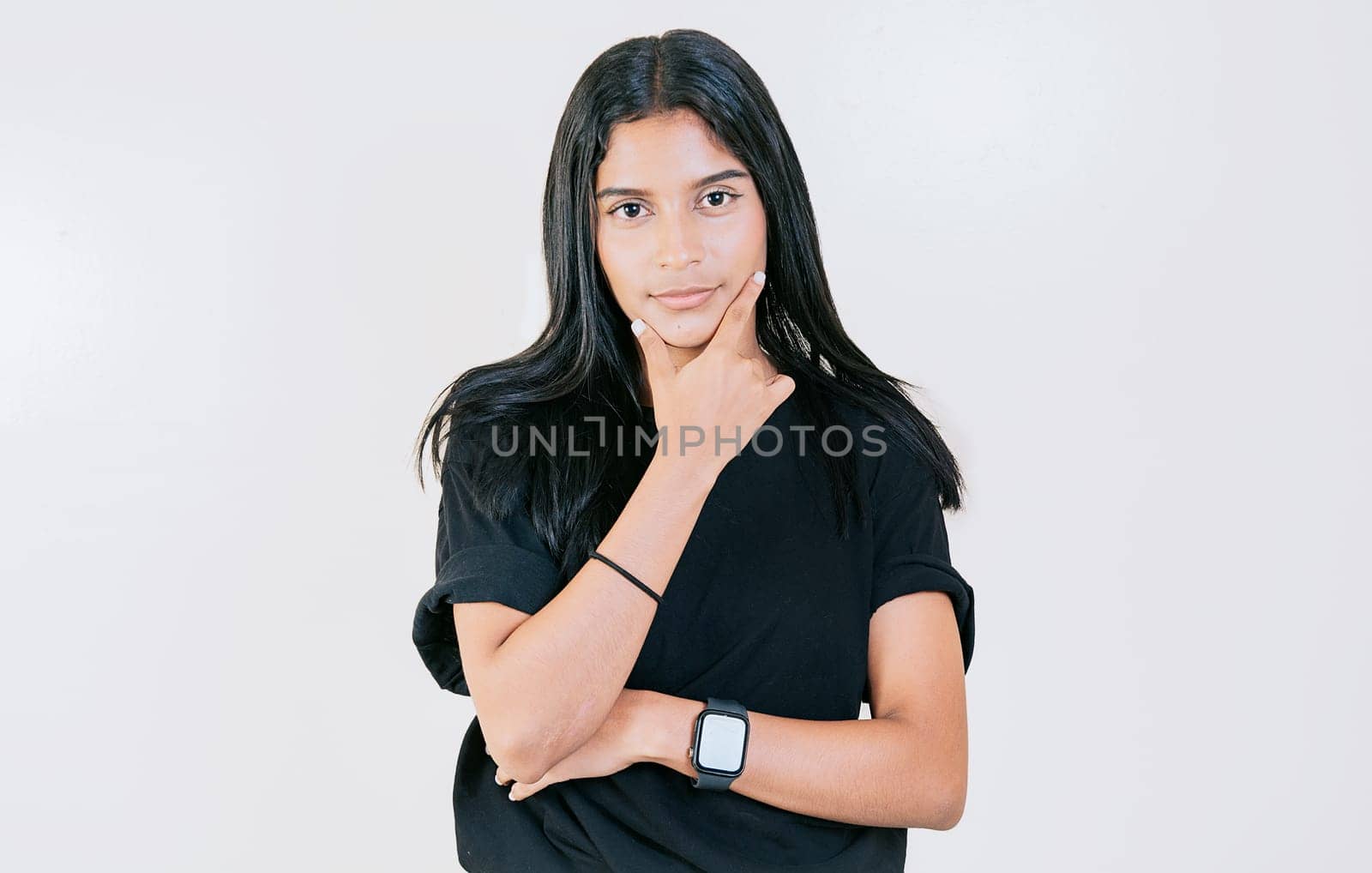 Portrait of young woman with hand on chin looking at camera. Smiling latin girl with hand on chin looking at camera by isaiphoto