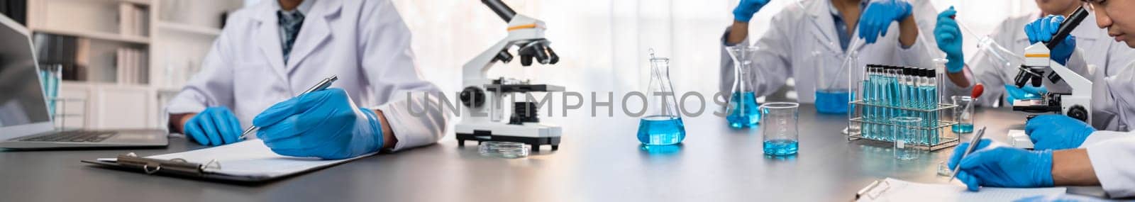 Group of dedicated scientist conduct chemical experiments and research in medical lab as groundbreaking developing for vaccine drug or antibiotic. Pharmaceutical and biochemistry laboratory. Neoteric