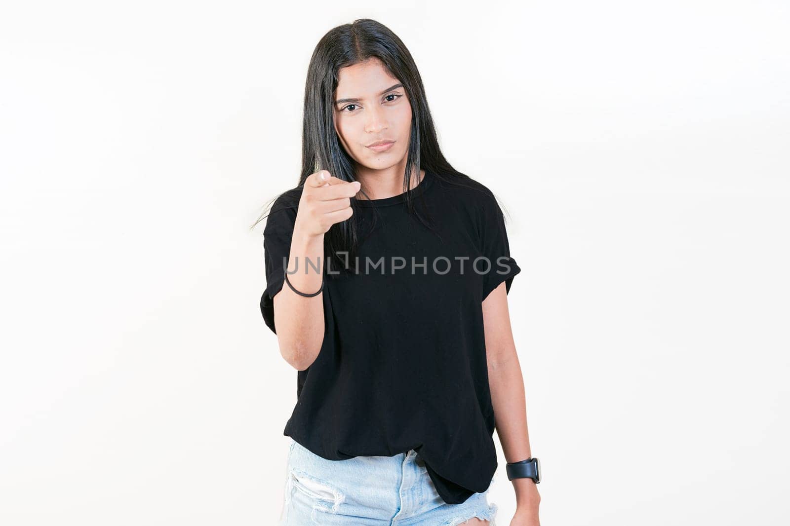 Young girl pointing at you frowning isolated. Serious girl pointing at the camera, isolated by isaiphoto