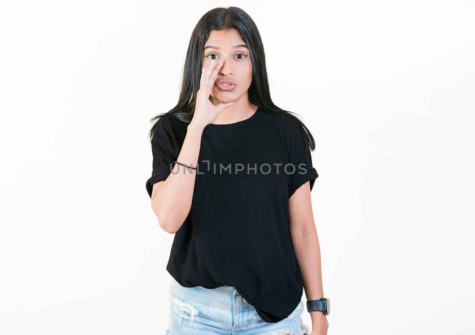 Girl whispering to the camera, isolated. Young woman whispering a promo to camera isolated. People whispering a promotion to the camera by isaiphoto