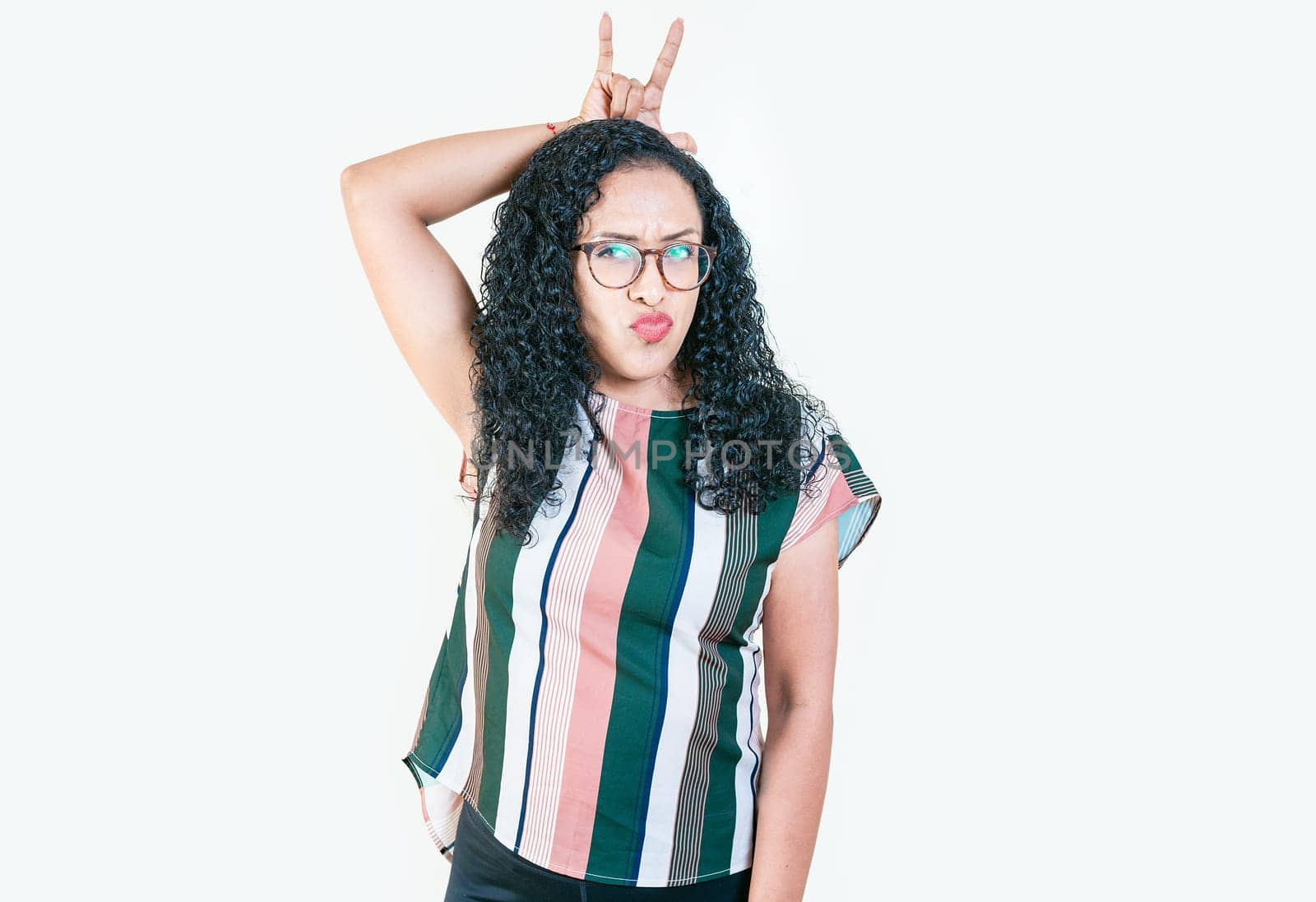 Young afro girl making horns gesture with fingers. Afro girl making horns gesture with their fingers, gesture of betrayal. Infidelity concept by isaiphoto