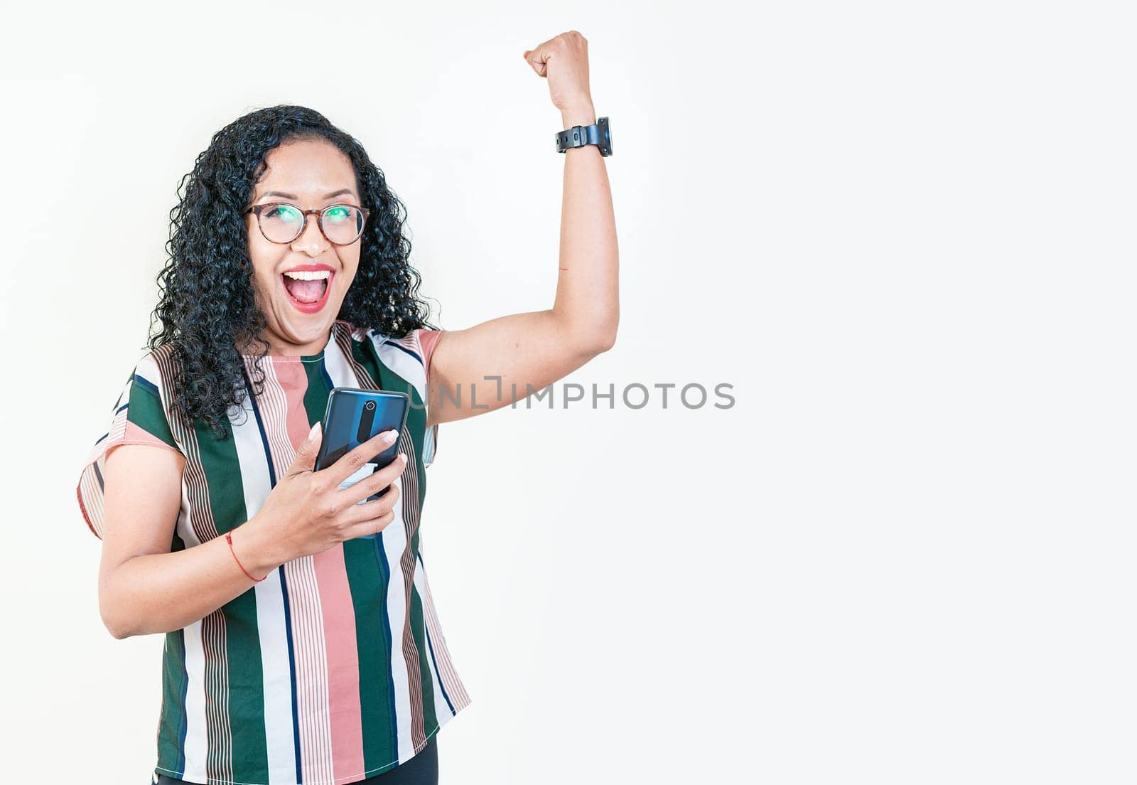 Happy afro woman holding smartphone and celebrating. Winner afro young girl holding phone excited isolated