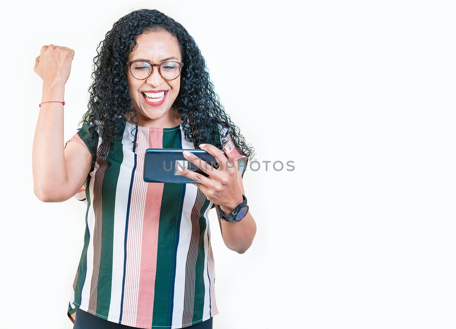 Excited young afro girl holding phone celebrating something. Happy afro woman holding smartphone and celebrating isolated by isaiphoto
