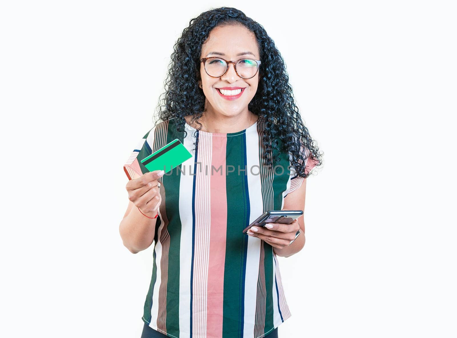 Happy young woman making online purchases with cell phones and credit cards. Smiling afro girl holding credit card shopping online with phone isolated