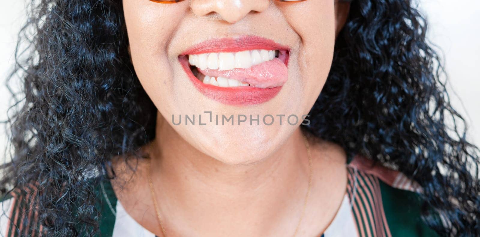 Close up of Girl mouth biting her tongue isolated. Close up of sexy girl biting tongue by isaiphoto