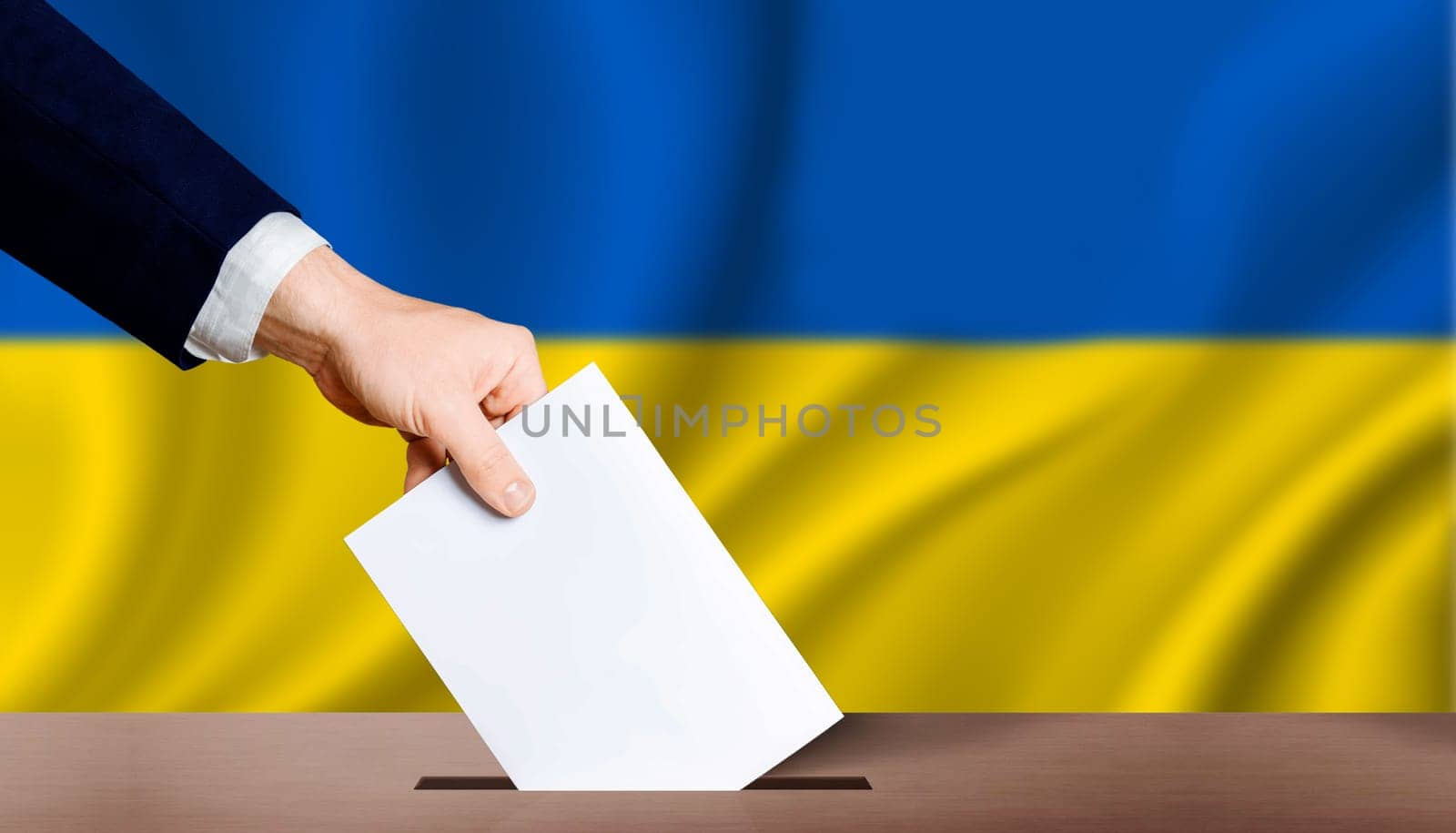 Hand holding ballot in voting ballot box with ukraine flag in background. People puts ballot paper in voting box on Ukraine flag background. Ukraine electoral elections, concept by isaiphoto