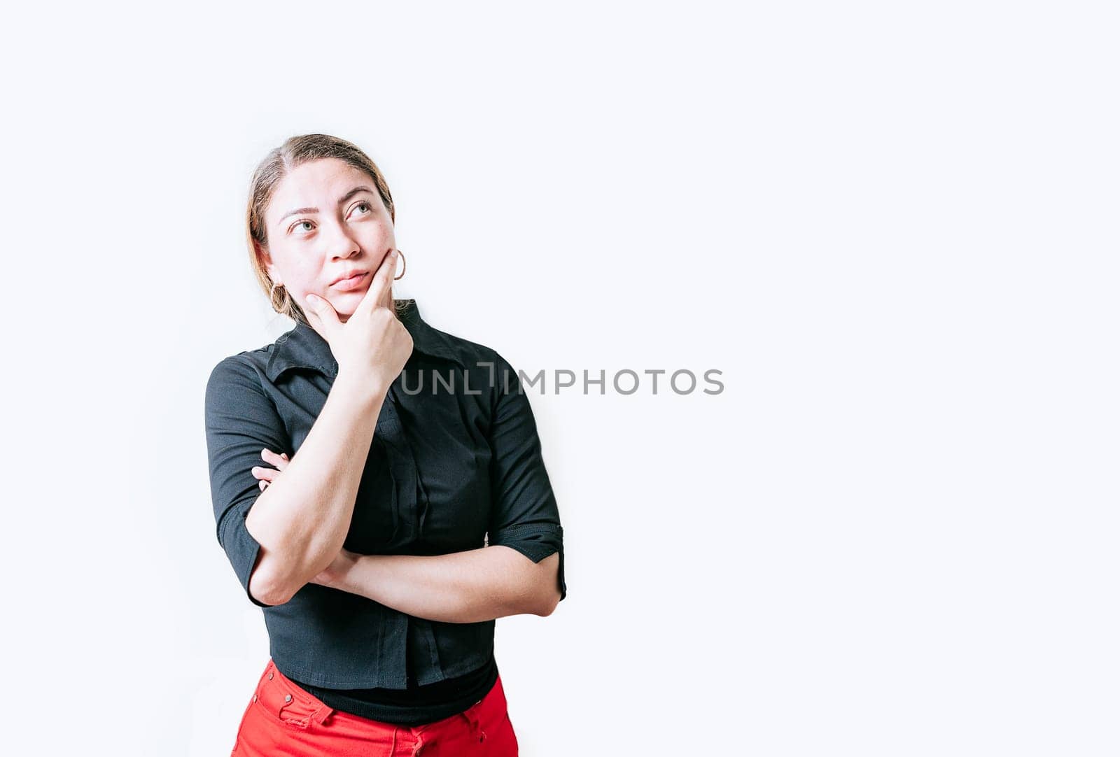 Pensive young woman with hand on chin meditating isolated. Beautiful girl thinking with hand on chin looking up by isaiphoto