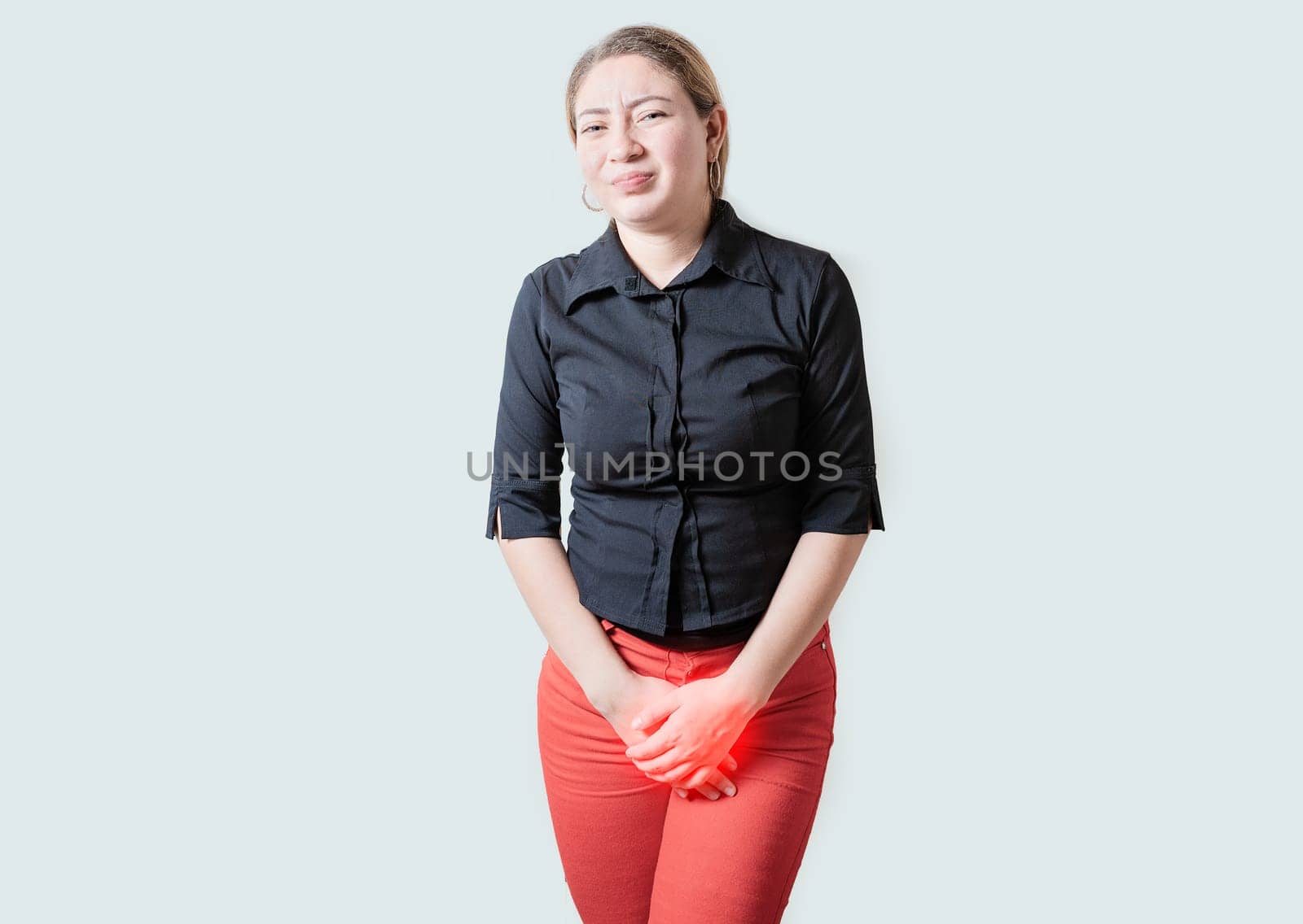 Young woman suffering with urinary problems isolated. Girl with hands on crotch with urinary problems by isaiphoto