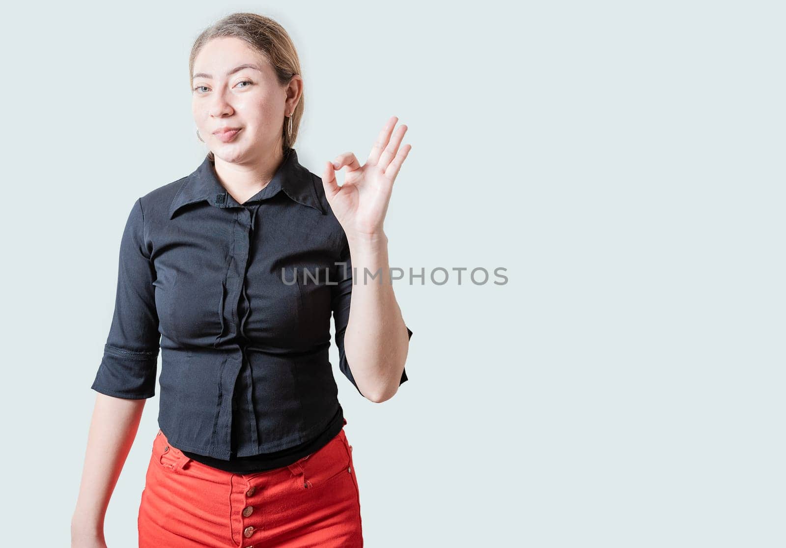 Positive beautiful girl showing ok gesture isolated. Portrait of cheerful young woman gesturing ok approved by isaiphoto