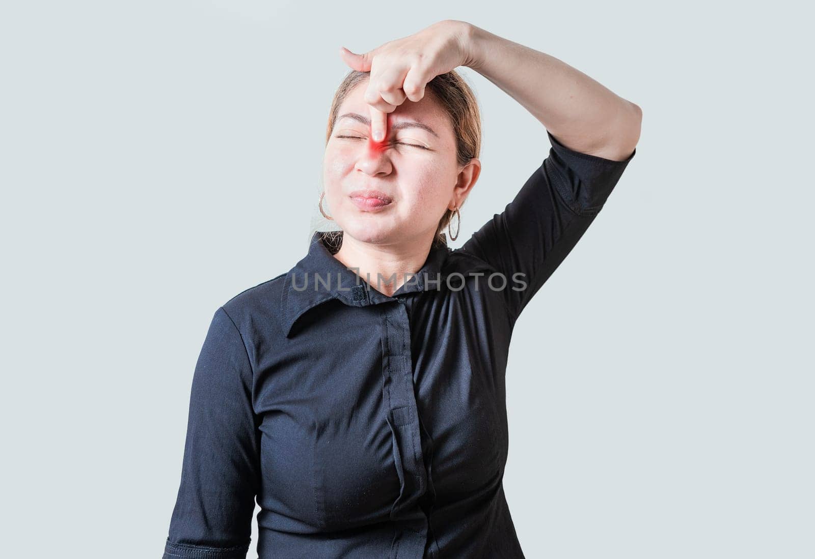 Young woman with pain touching nose. People with nasal bridge pain, Girl with nasal bridge headache. Sinus pain concept by isaiphoto