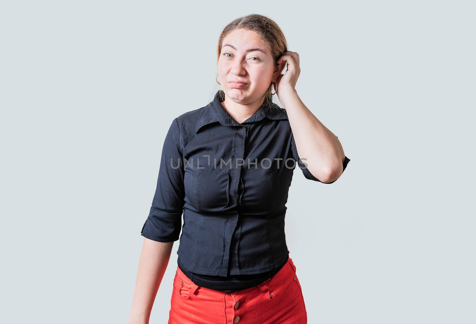 Person scratching head with indecisive expression isolated. Cute woman scratching her head with doubtful expression by isaiphoto