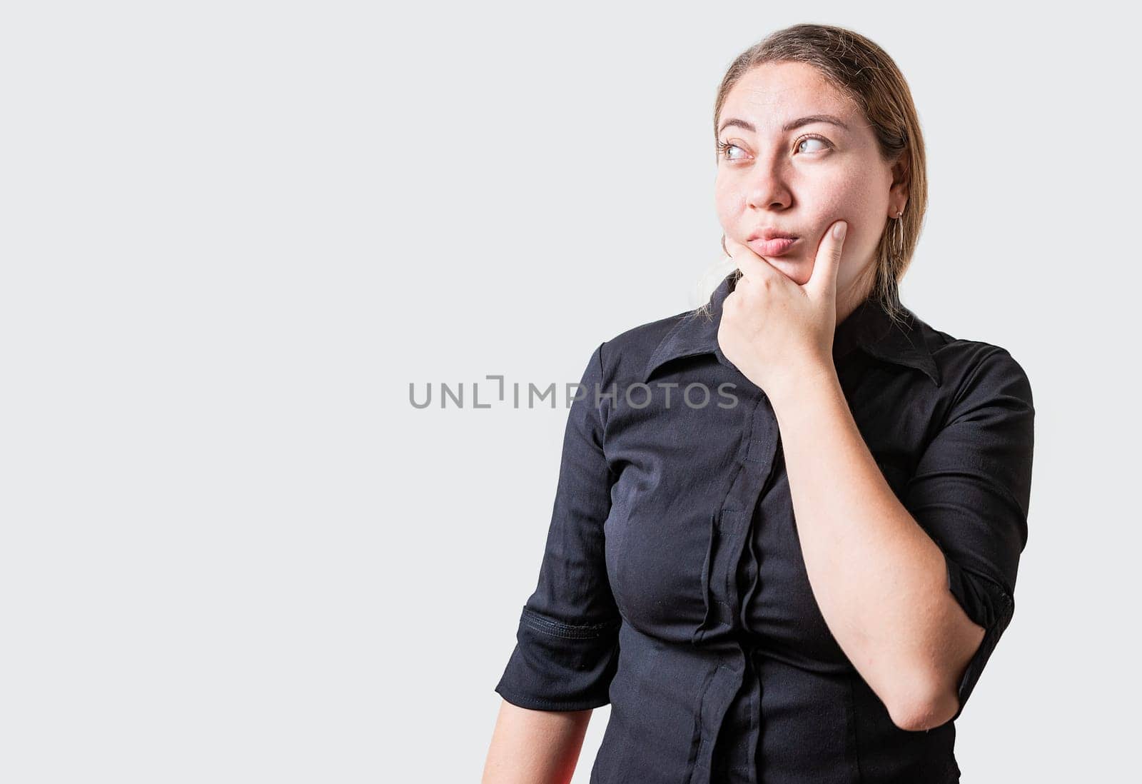 Young woman thinking with hand on chin isolated. Thoughtful beautiful girl with hand on chin isolated by isaiphoto