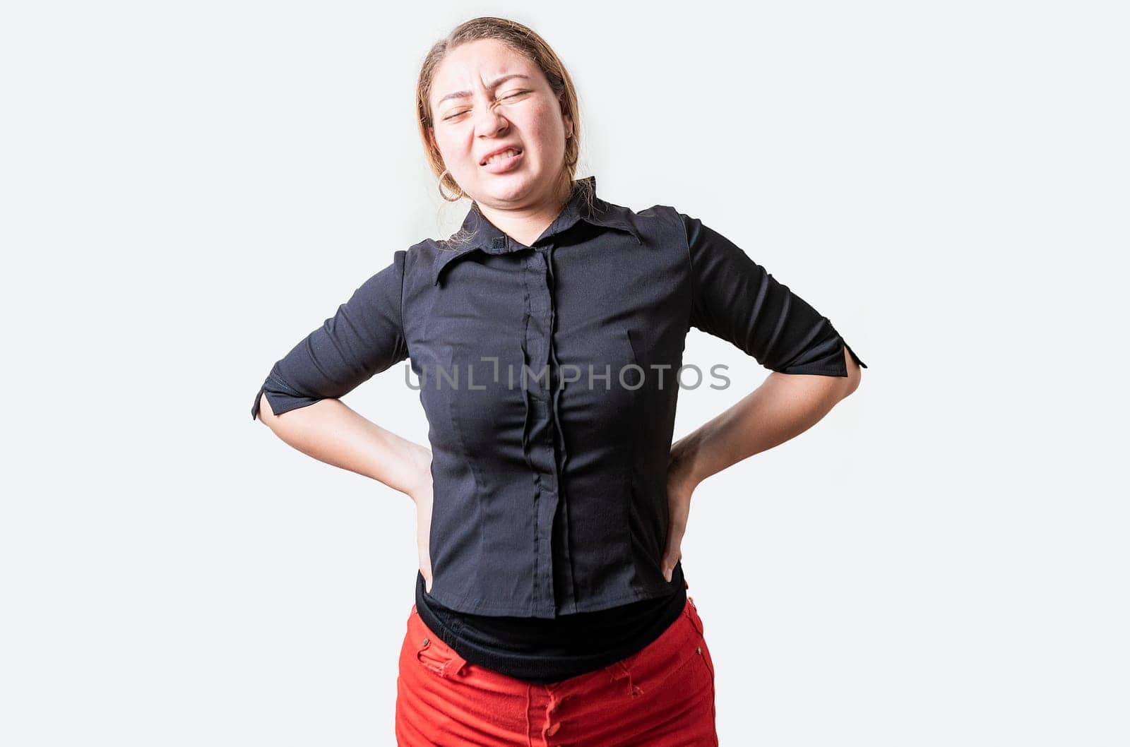 Suffering girl with back pain. Young woman with back pain. Lumbar problems concept. People with spine problems isolated by isaiphoto
