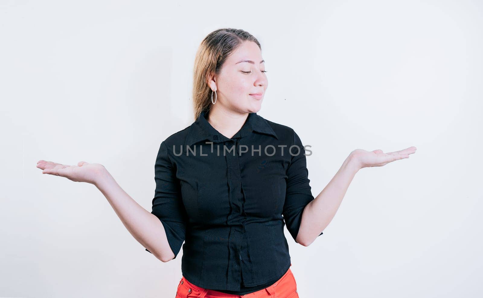 Smiling woman comparing with palms with hands isolated. Girl balancing something with palms isolated by isaiphoto