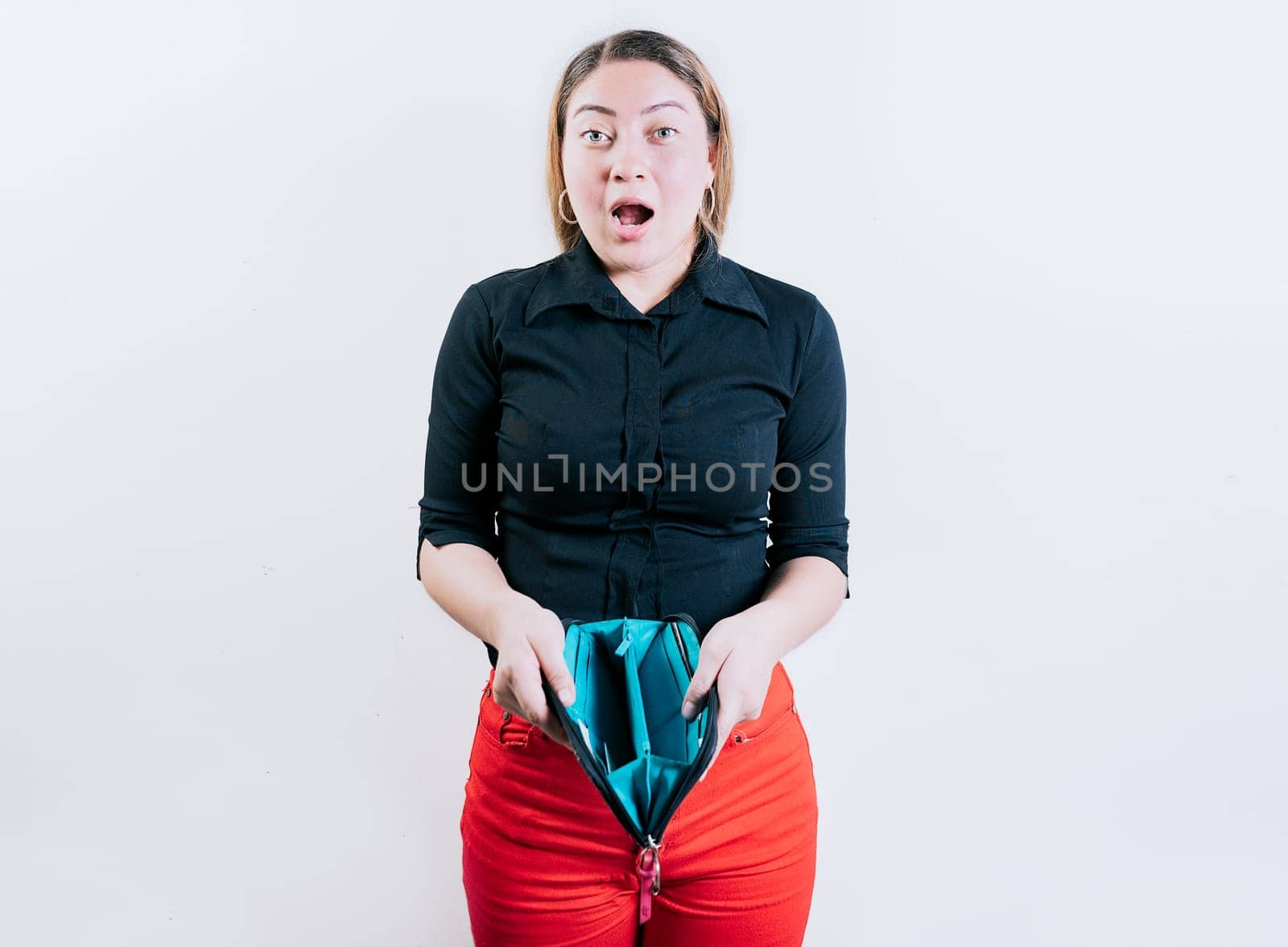 Shocked young woman showing empty wallet isolated. Unemployed girl without money showing empty wallet by isaiphoto