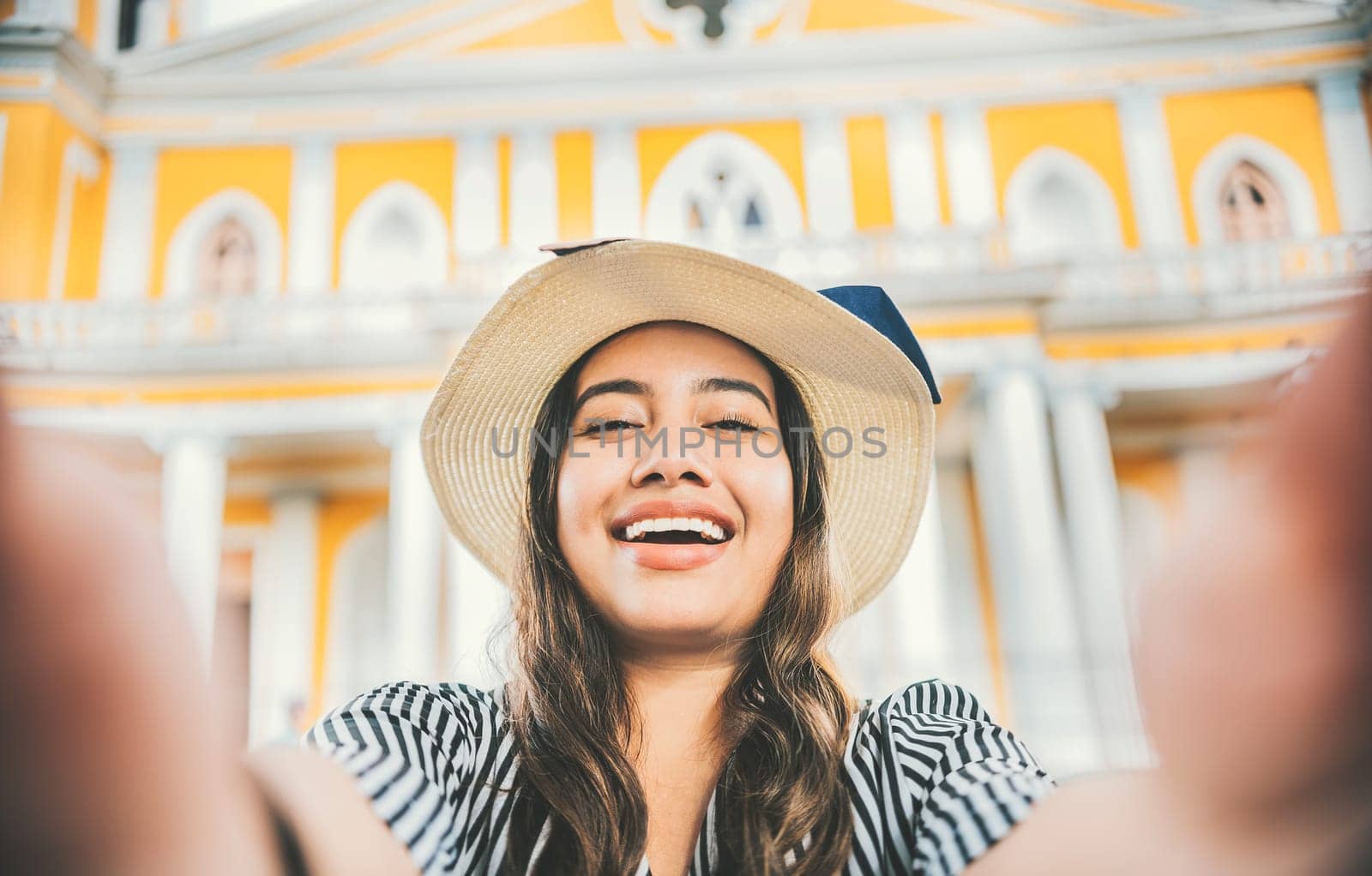 Smiling tourist girl in hat taking a selfie in a square. Lifestyle of tourist girl in hat taking a selfie in a square. Granada, Nicaragua by isaiphoto