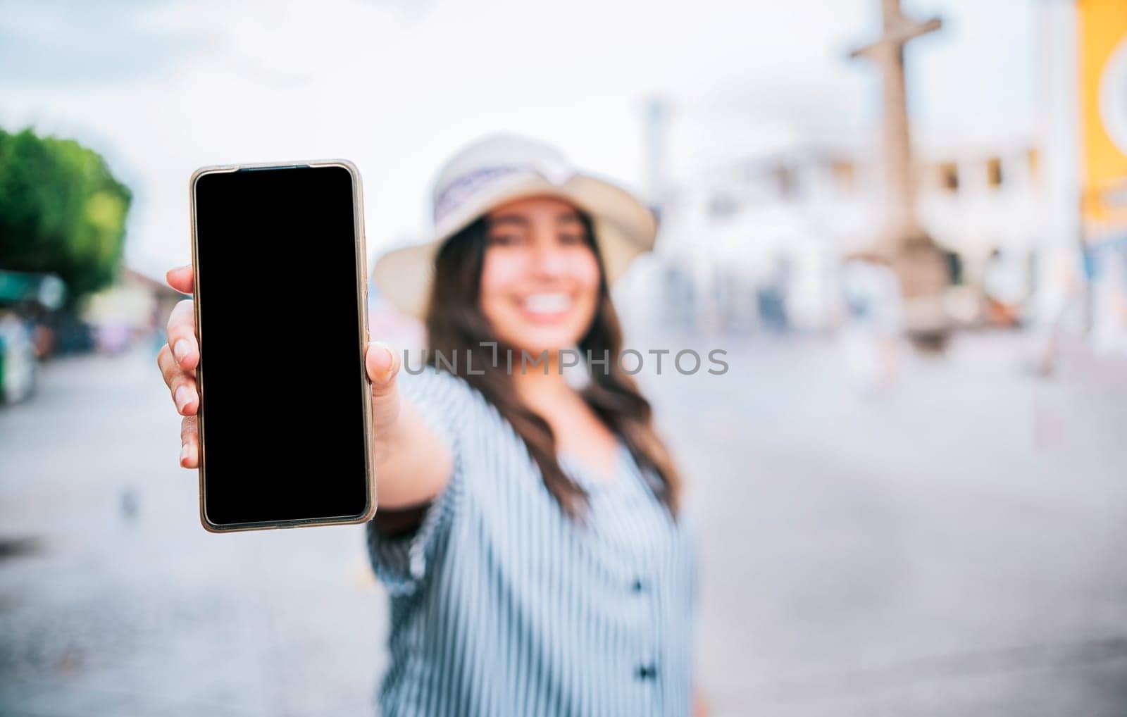 Tourist girl showing cell phone screen on the street. Travel woman showing cell phone screen on the street by isaiphoto